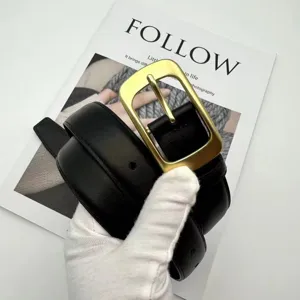 Detailed close-up view of a stylish black genuine leather belt featuring a vintage brass buckle.