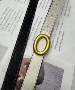 Primo piano dettagliato di un'elegante cintura reversibile da donna con fibbia in ottone.
