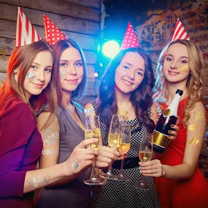 Party scene detail showing gold and silver temporary tattoos applied on arms and face clearly.