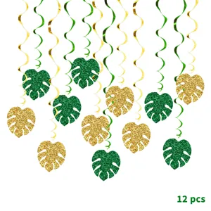 Detail view of Hawaiian party hanging swirl decorations with glittering green and gold monstera leaves.