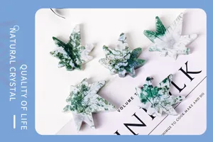 Detailed close-up of natural moss agate maple leaf crystal carving, showing unique green texture.
