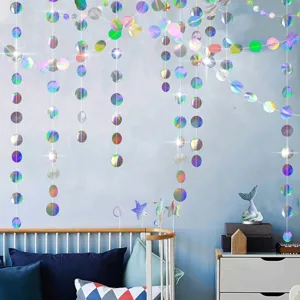 Holographic round paper garland hanging on wall, perfect party decoration scene detail view.