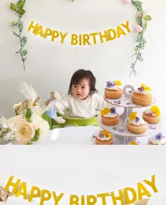Detailed shot of golden glitter happy birthday letter banner in a cute party scene.