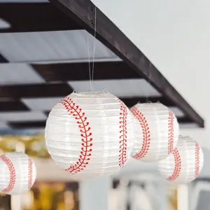 Hanging baseball paper lantern detail showing red stitching texture and party decor setup.