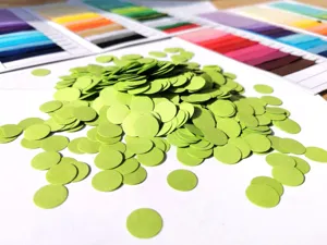 Green round paper confetti filling for party decoration, colorful paper dots for gift box packaging.