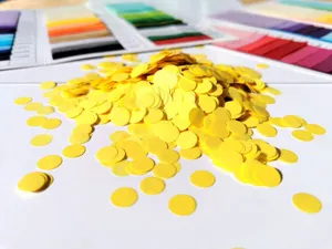 Yellow round confetti paper dots detail shot for party decoration and festive celebration events.