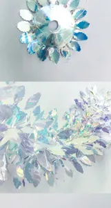 Close-up detail of holographic iridescent flower hanging ornament, dazzling reflective party decor.