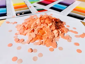 Colorful round paper confetti for party decoration and gift box filling, orange tone.