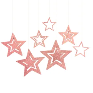 Close-up details of hanging pink glitter star ornaments, perfect for party decorations.