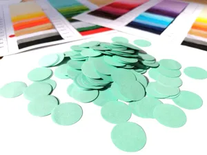 Close-up detail shot of light green paper confetti circles, perfect for party decor fills.