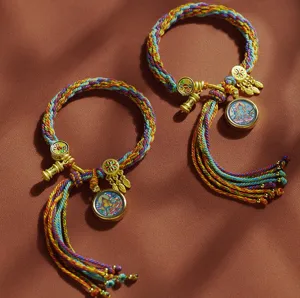 Nahaufnahme handgefertigter tibetischer geflochtener bunter Armbänder mit Thangka-Anhänger.