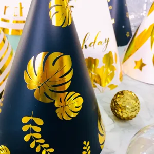Detailed close up of gold foil birthday party hats with botanical leaf patterns for kids.