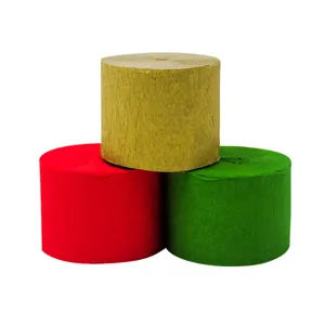 Close-up detail of colorful crepe paper rolls in gold, red and green for party decor.