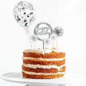 Silver birthday cake topper detail featuring confetti balloon and happy birthday sign.