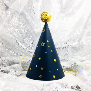 Close up detail view of a dark blue children birthday party cone hat with gold stars and pompom.