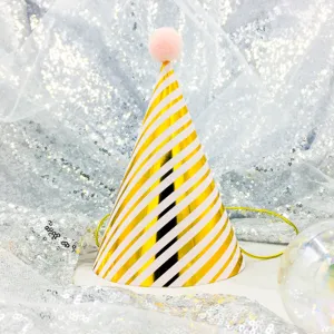 Gold and white striped party hat closeup, pink pom pom, celebration accessory.