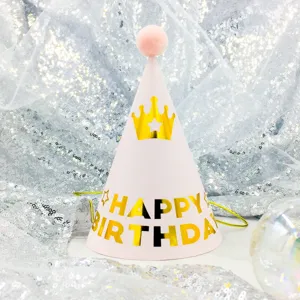 Pink cone birthday party hat for kids with pom pom and golden crown print decoration.