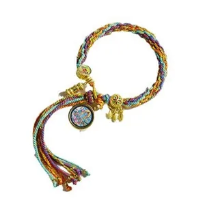 Tibetischer handgefertigter bunter geflochtener Armreif mit Metallanhängern und Quaste.