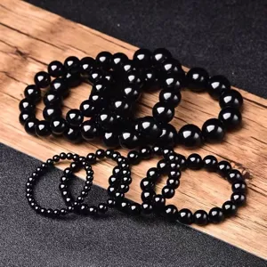 Dettaglio del bracciale di perle in ossidiana nera con perline di pietre preziose rotonde e lucide.