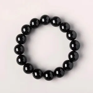 Primo piano del bracciale di perle in ossidiana nera con dettagli di superficie lucide e lisce.