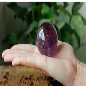 Close-up detail of natural Brazilian amethyst crystal egg gemstone polished ornament.