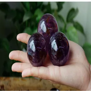 Close-up of natural polished purple amethyst crystal eggs, smooth surface detail view.
