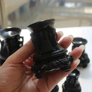 Detailed view of black carved wooden base for crystal spheres and gemstone display items.