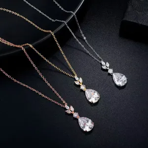 Close-up detail of three teardrop zirconia necklaces in rose gold, gold, and silver.