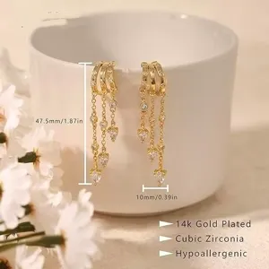 Vista dettagliata di orecchini pendenti placcati oro con zirconi cubici a forma di cuore.