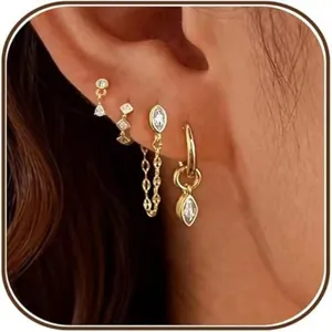 Detail view of trendy gold plated brass multi piercing chain drop earrings with sparkling studs.