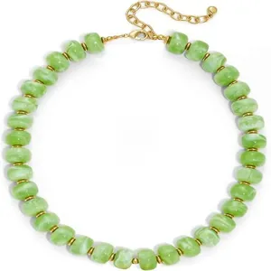 Détail de collier de perles vertes, perles d'espacement dorées, bijou de mode élégant.