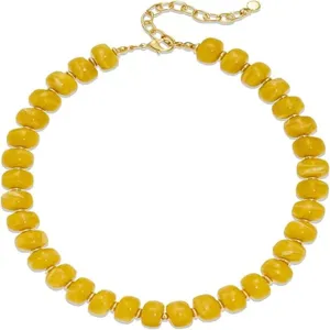 Détail de collier de perles jaunes plaqué or, accessoire de mode élégant pour femme.