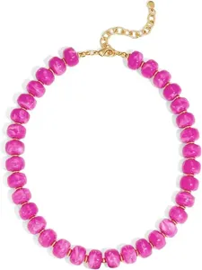 Collier de perles marbrées fuchsia tendance avec éléments dorés et fermoir réglable.