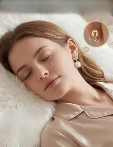 Closeup detail of elegant gold knot pearl drop earrings with comfortable clip on design.