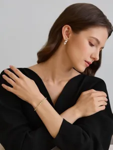 Nahaufnahme des eleganten vergoldeten Kristallarmbands, getragen von einem Model mit schwarzem Top.