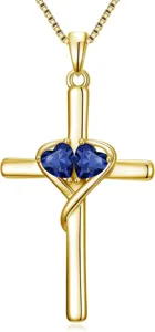 Detailed close-up of gold-tone cross pendant necklace with sparkling blue double heart stones.