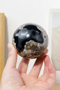 Detailed close-up view of polished natural volcanic agate crystal sphere showcasing patterns.