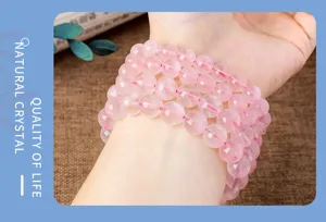 Nahaufnahme des mehrlagigen Perlenarmbands aus natürlichem Rosenquarz am Handgelenk.