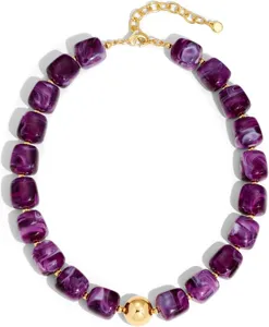Collier de perles en résine violette avec détails dorés et pendentif boule central pour l'été.