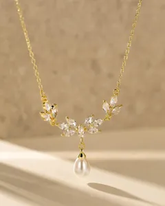 Vista de detalle de un elegante collar con colgante de perla y mariposa chapado en oro.
