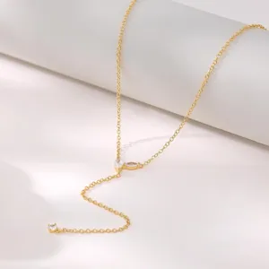 Primo piano di una collana a Y placcata in oro con zirconi scintillanti e catena delicata.
