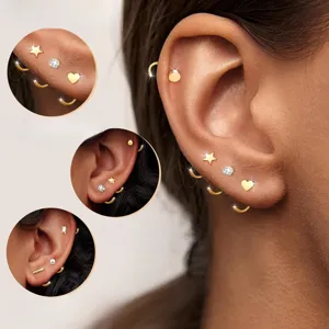 Ensemble de boucles d'oreilles créoles et puces dorées avec étoiles, cœurs et cristaux.