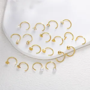 Gros plan détail de boucles d'oreilles créoles dorées assorties avec divers pendentifs.