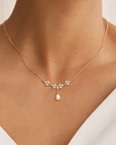 Elegante collar de cadena de clavícula dorada con hojas de circonita y delicado colgante de perla.