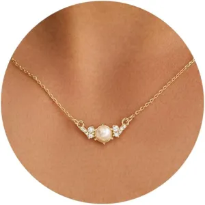 Detalle exquisito de collar de perlas, cadena dorada delicada con circones brillantes.