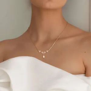 Elegante collar de clavícula bañado en oro con circonita en hoja y perla colgante.
