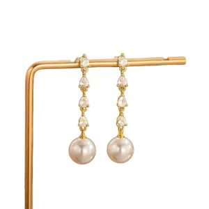Elegante lange Ohrhänger mit funkelnden birnenförmigen Zirkonia und glänzenden Perlen.