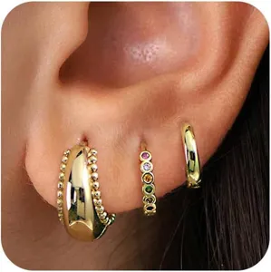 Detail shot showing multiple gold hoop earrings worn on earlobe for a stylish stacked look design.