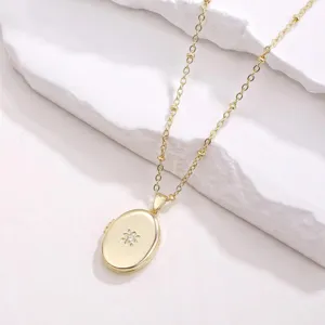 14k gold plated brass oval locket necklace featuring sparkling zircon flower detail.