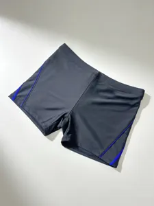 Detailoverzicht zwarte herenzwembroek, blauwe bies, stijlvolle sportieve look.